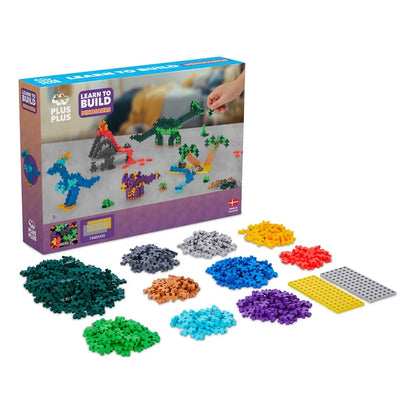 Three different Plus-Plus dinosaurs built and standing together on the included baseplates