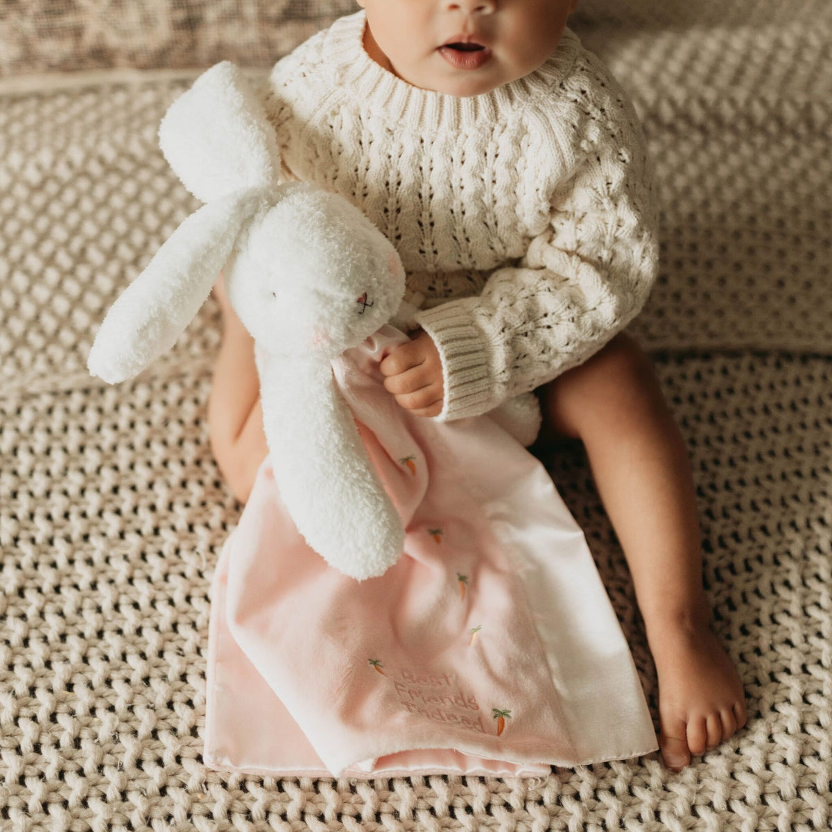 Baby cuddling the Blossom Bunny Buddy Blanket