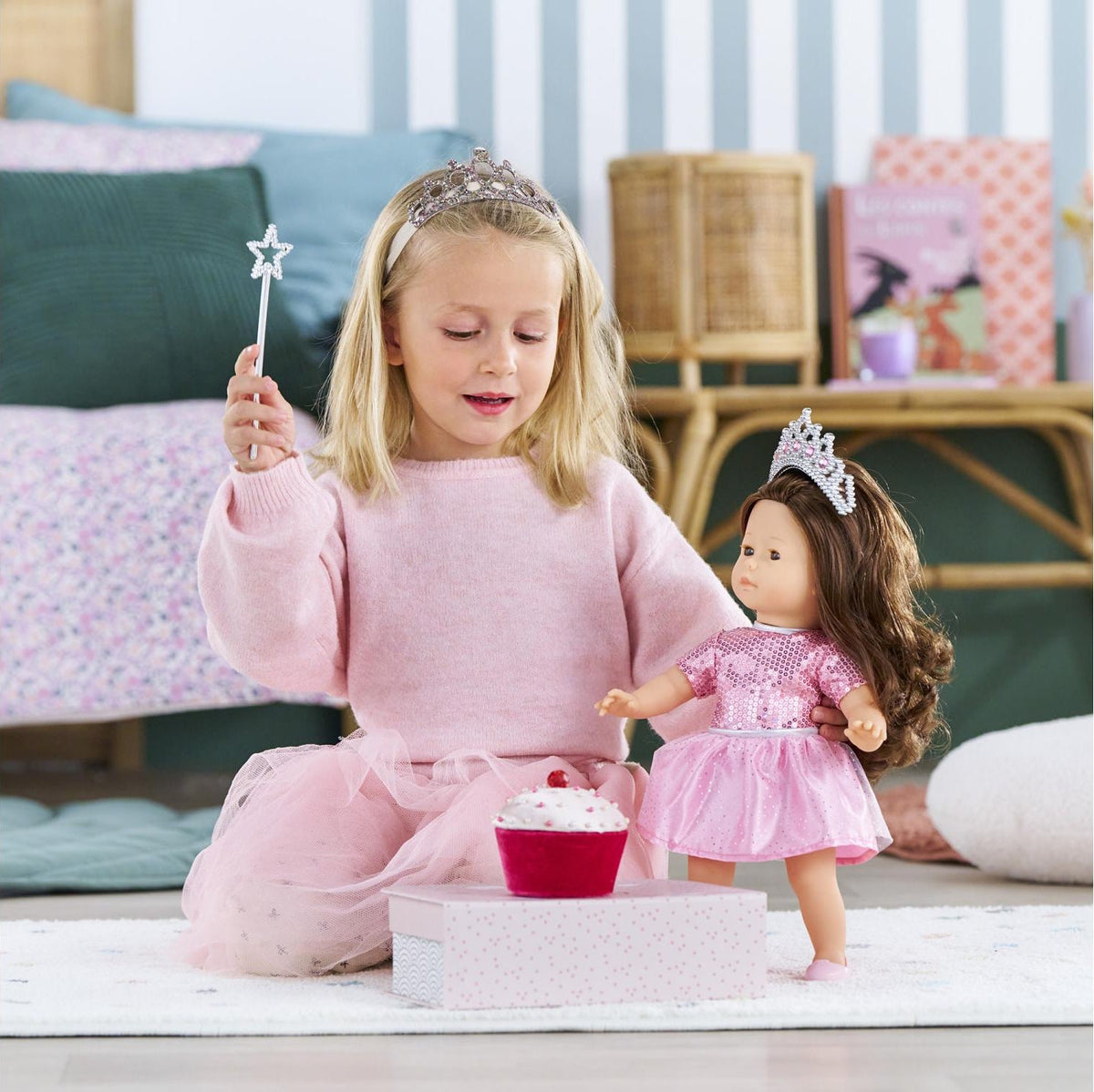 Child holding star wand with Ma Corolle doll wearing pink princess dress and tiara