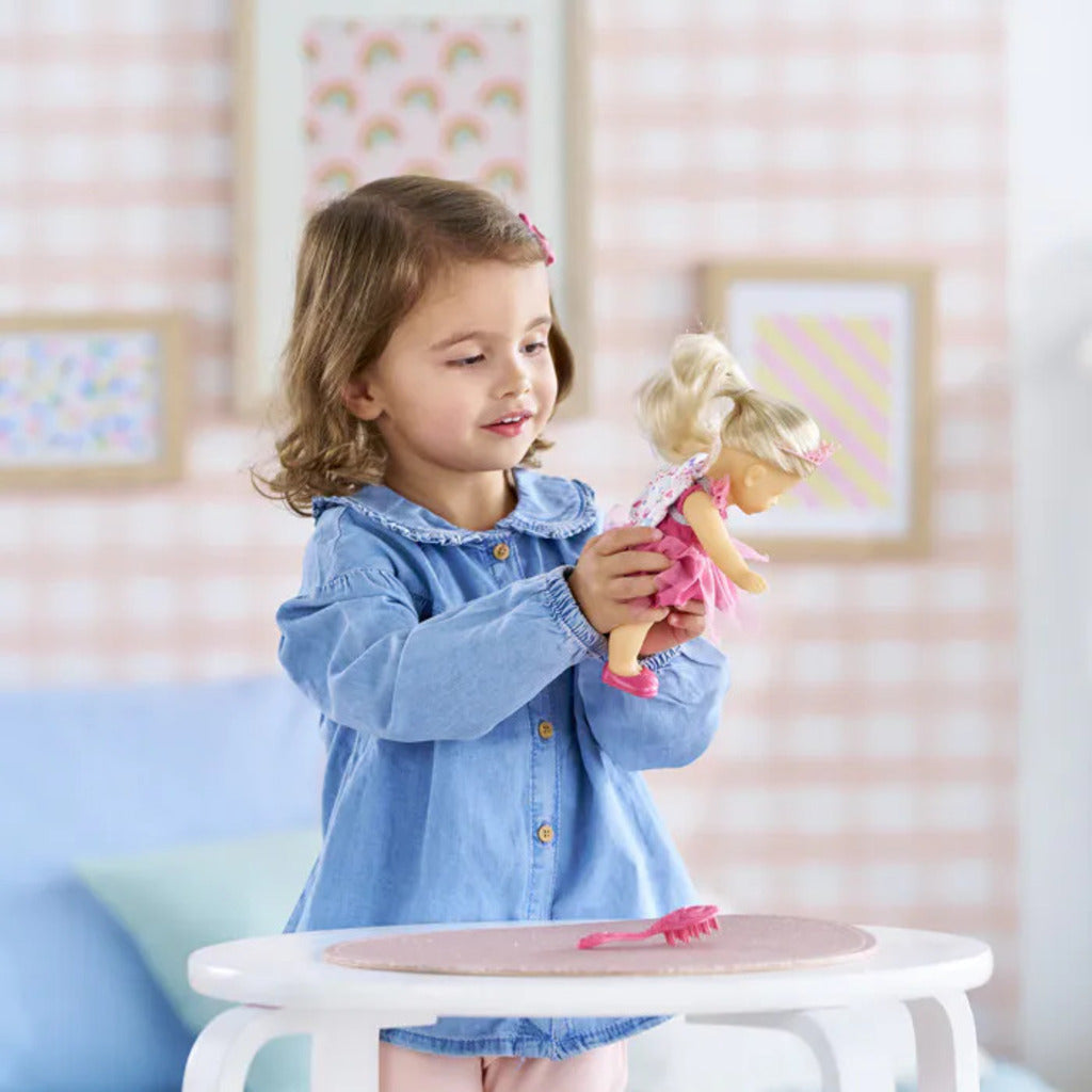 Child holding the 20cm Rosy Fairy doll, small enough to fit into a backpack or coat pocket