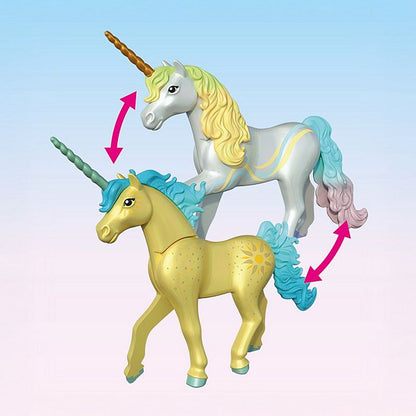 Two unicorn figurines, one white with a blue mane and horn, and the other yellow with a green horn, on a light pink background.